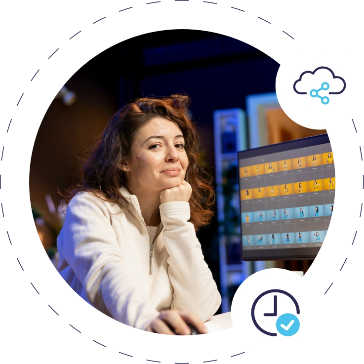 Woman in white sweater smiling at desk, colorful screen, cloud icons.