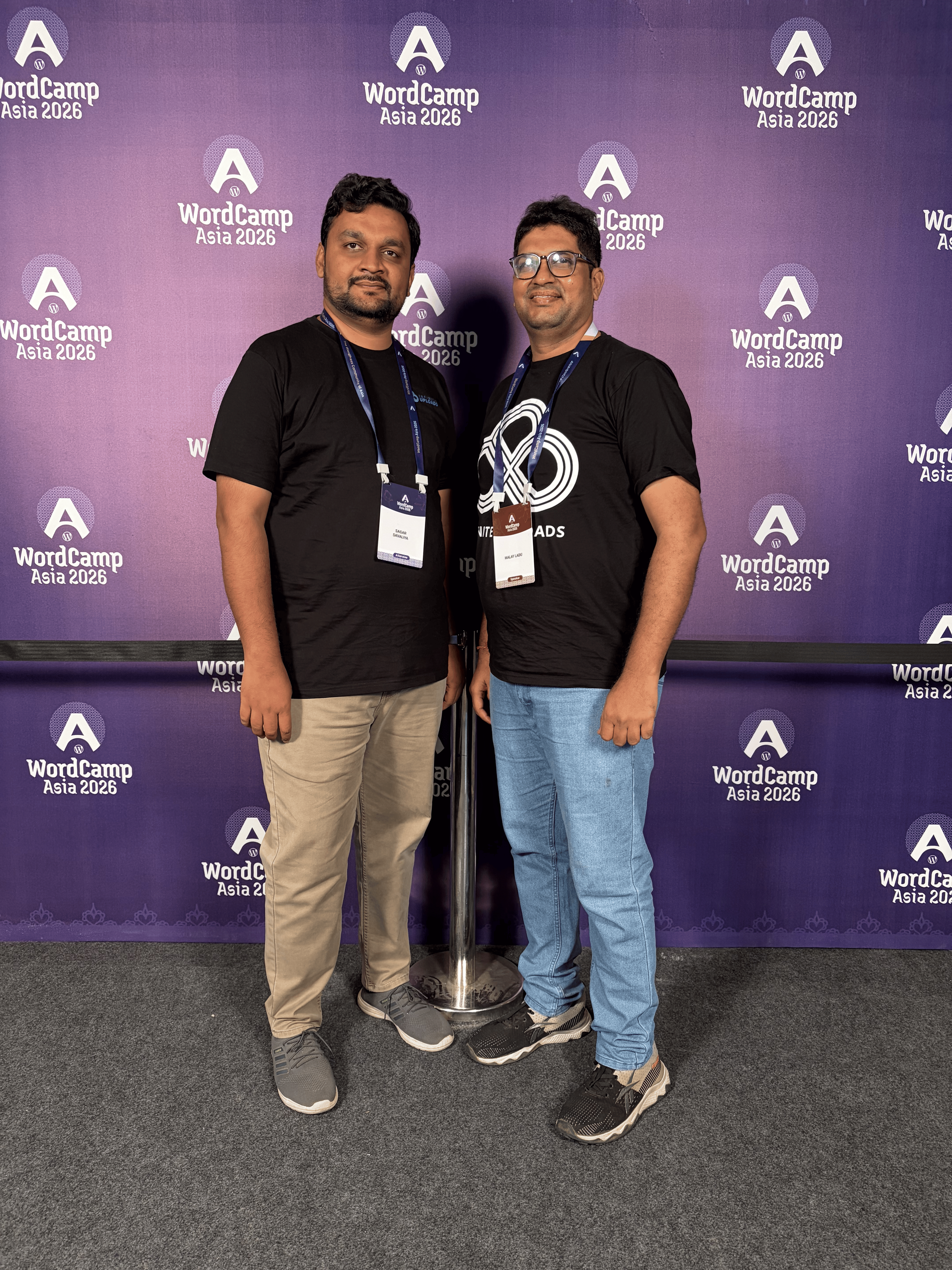 Two men standing, wearing black shirts, at WordCamp Asia 2026 event.